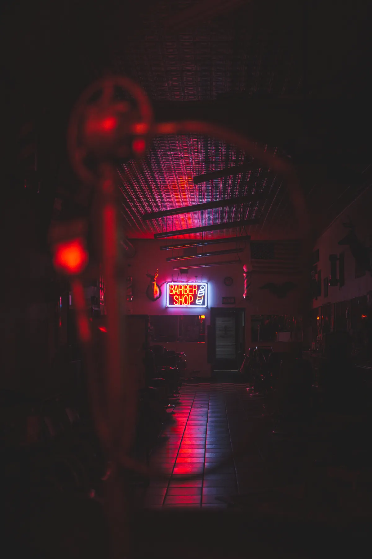 Neon “Barber Shop” sign glowing at the end of a dark corridor